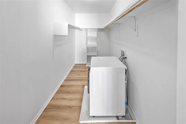 a utility room with wooden floor washer and dryer