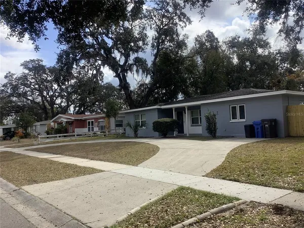 a front view of a house with a yard and trees
