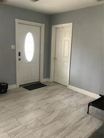 an empty room with wooden floor and mirror