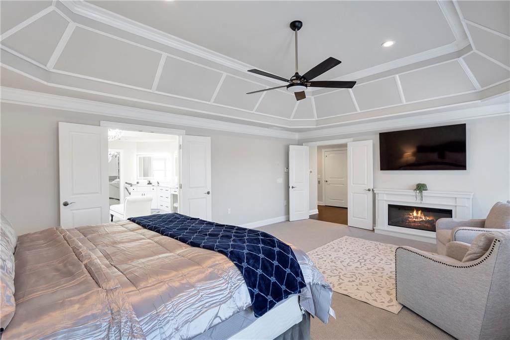 5755 Riley Road Cumming, GA 30028 - Photo 32 of 77 a bedroom with a bed a flat screen tv and a couch