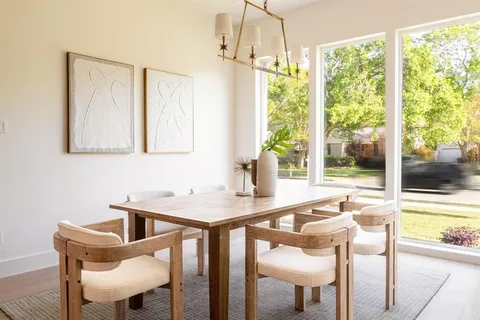 a view of a dining room with furniture a chandelier and wooden floor