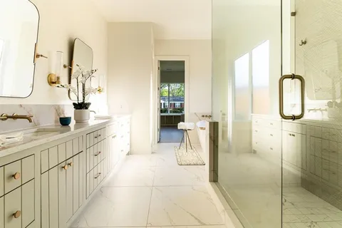 a spacious bathroom with a double vanity sink a mirror and a shower