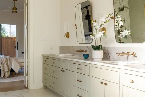 a bathroom with cabinets and mirror