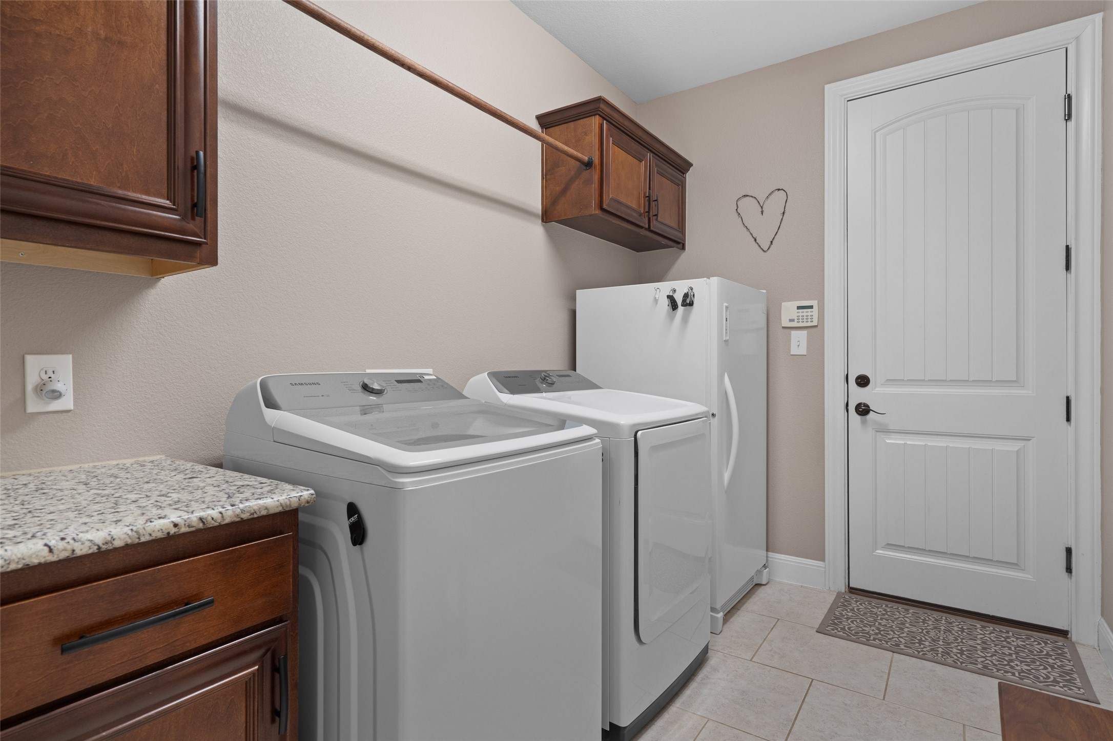 164 Milestone Road Liberty Hill, TX 78642 - Photo 16 of 40 Laundry area featuring cabinet space, washing machine and clothes dryer.