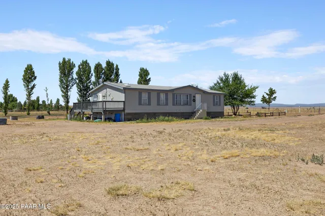 a view of a house with a yard and potted plants