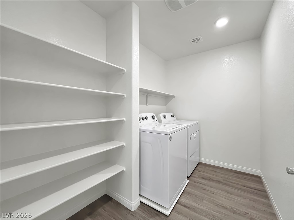9984 Indigo Cliffs Street Las Vegas, NV 89141 - Photo 13 of 31 Washroom featuring dark wood-style floors, laundry area, washing machine and dryer, and baseboards