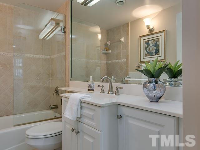 401 Mumm Lane Raleigh, NC 27615 - Photo 21 of 25 a bathroom with a granite countertop sink a toilet and shower
