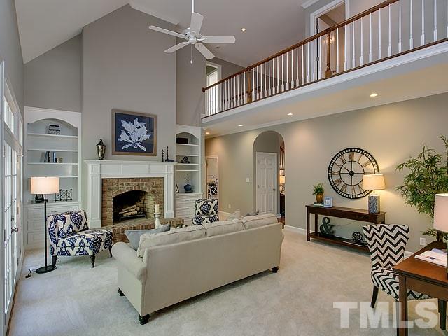 401 Mumm Lane Raleigh, NC 27615 - Photo 6 of 25 a living room with furniture a fireplace and a chandelier