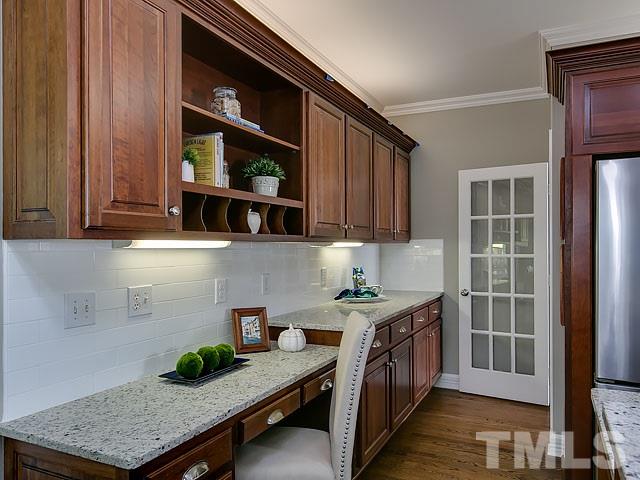 401 Mumm Lane Raleigh, NC 27615 - Photo 9 of 25 a kitchen with stainless steel appliances a stove a microwave and cabinets