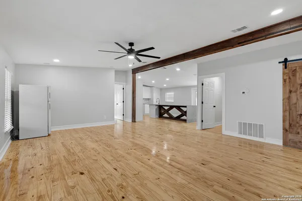 a view of empty room with wooden floor and a ceiling fan