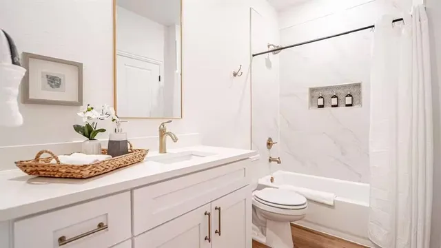 a bathroom with a granite countertop sink a toilet and shower