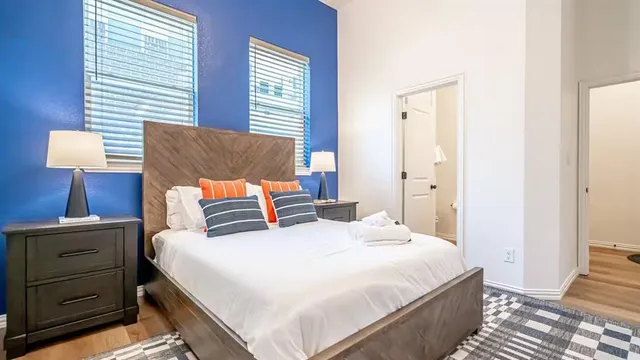 a bedroom with a bed and a lamp on dresser