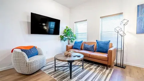 a living room with furniture a flat screen tv and a window