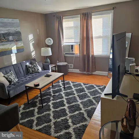 a living room with furniture a rug and a lamp
