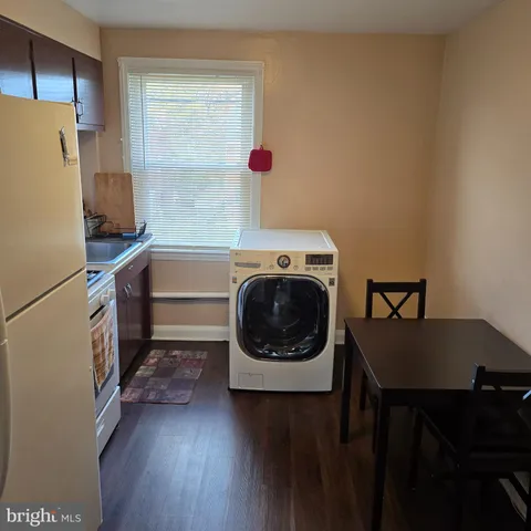 a utility room with wooden floor washer and dryer