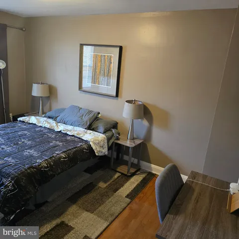 a bedroom with a bed and wooden floor