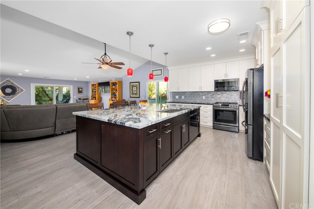 1817 Balboa Way Upland, CA 91784 - Photo 12 of 55 a kitchen with stainless steel appliances granite countertop a stove a sink dishwasher a refrigerator and a oven with wooden floor