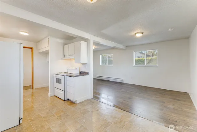 a kitchen with granite countertop white cabinets and white appliances