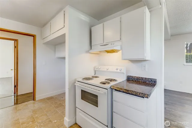 a kitchen with granite countertop a sink and a refrigerator