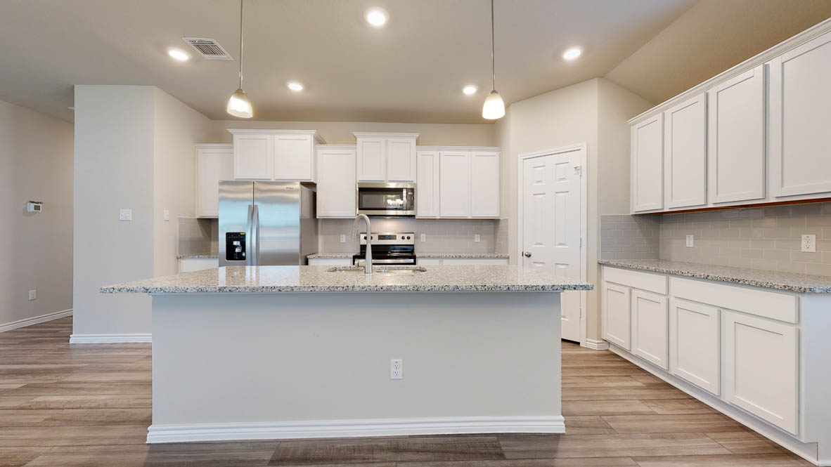 104 Kenzie Street Thorndale, TX 76577 - Photo 6 of 28 a kitchen with stainless steel appliances granite countertop a stove a sink and white cabinets