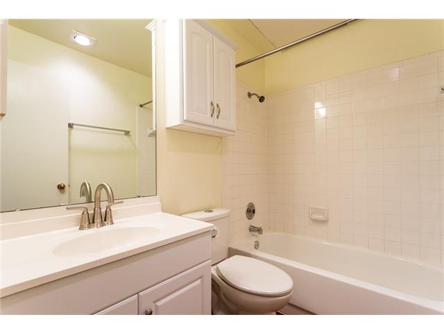 2804 Rio Grande Street, Unit 204 Austin, TX 78705 - Photo 9 of 12 A well-appointed bathroom features a single vanity, ample mirror, and tiled shower-tub combination.