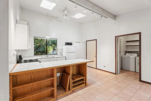 a kitchen with kitchen island a sink stove and refrigerator