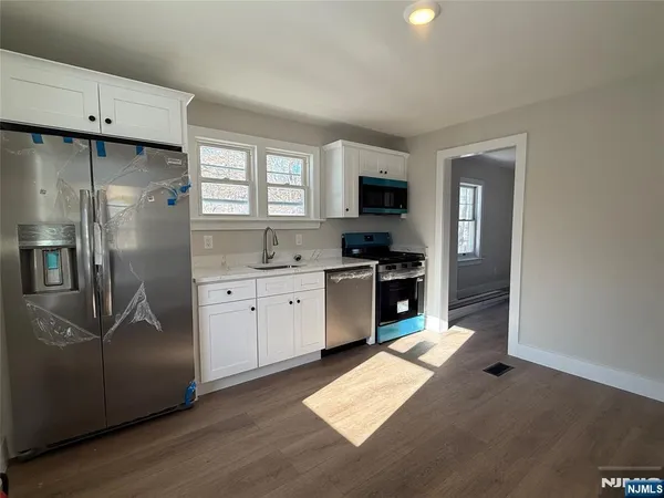 a kitchen with stainless steel appliances a refrigerator sink and stove