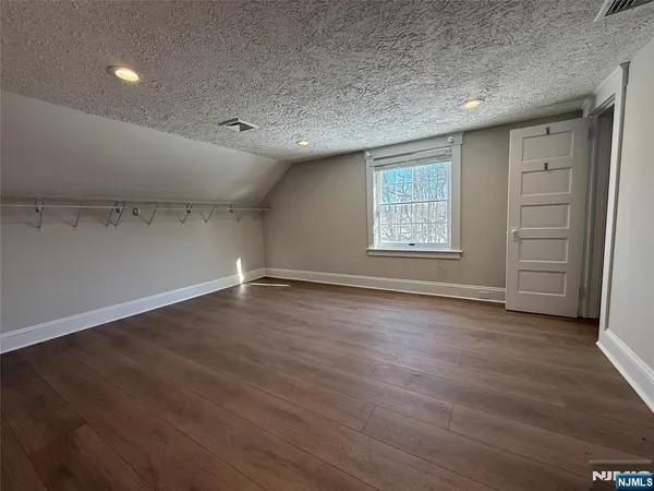 an empty room with wooden floor and window