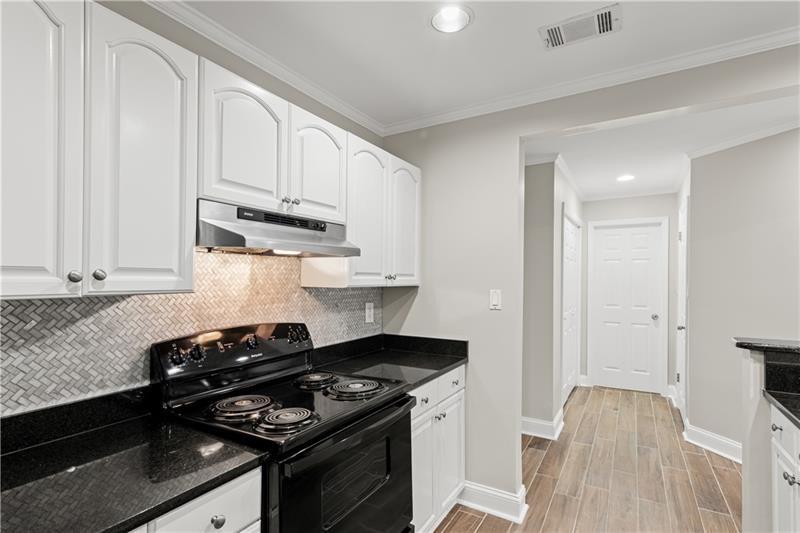 3655 Habersham Road Northeast, Unit A108 Atlanta, GA 30305 - Photo 21 of 30 a kitchen with stainless steel appliances granite countertop a stove and a white cabinets