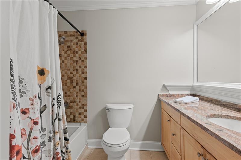 3655 Habersham Road Northeast, Unit A108 Atlanta, GA 30305 - Photo 8 of 30 a bathroom with a granite countertop toilet a sink and a shower