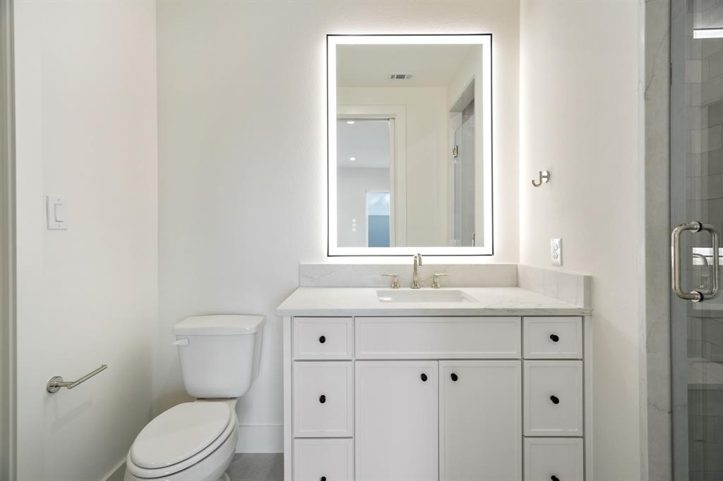 3316 Ferguson Road Grapevine, TX 76092 - Photo 32 of 39 a bathroom with a toilet a sink a mirror and vanity