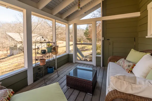 a view of a hallway with wooden floor and windows