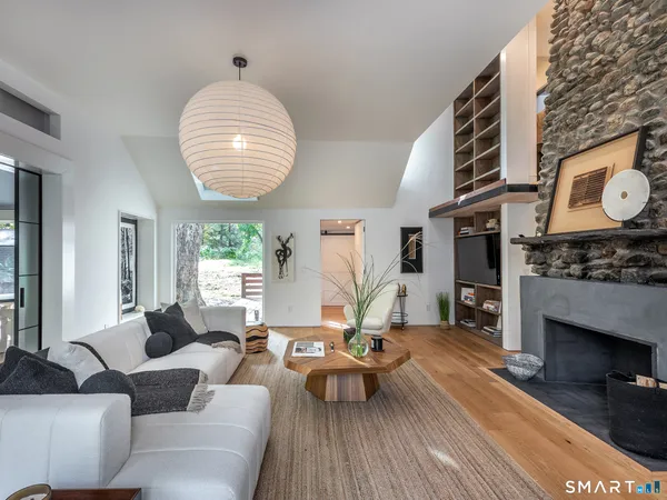 a living room with furniture a fireplace and a large window