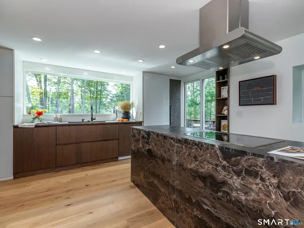 a kitchen with stainless steel appliances granite countertop wooden cabinets and a large window