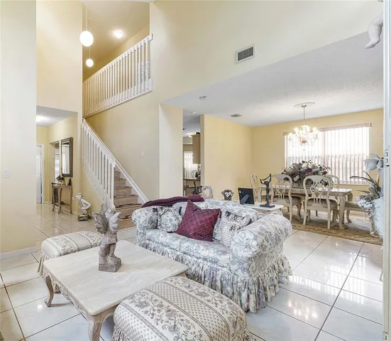 a living room with furniture and a dining table with kitchen view