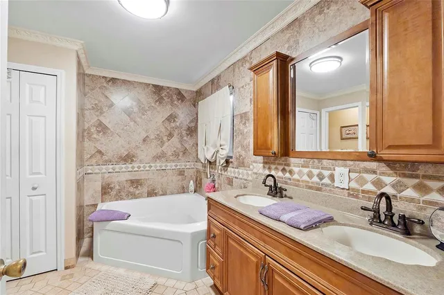 a bathroom with a tub a sink and mirror