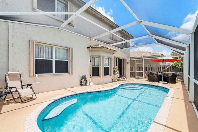 a view of a house with swimming pool and sitting area
