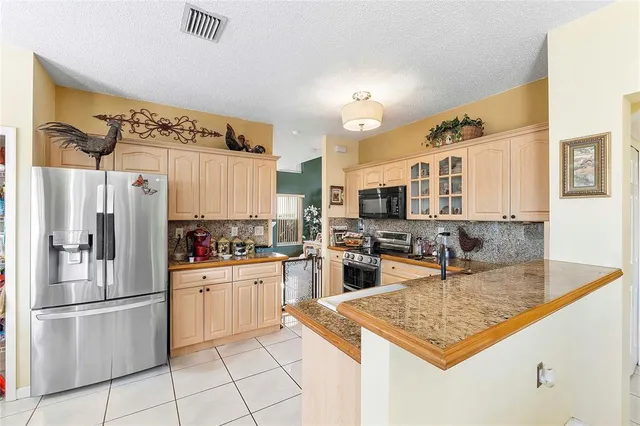 a kitchen with stainless steel appliances granite countertop a refrigerator and a sink