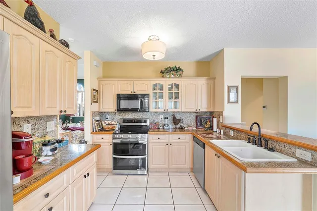 a kitchen with stainless steel appliances a sink stove and cabinets