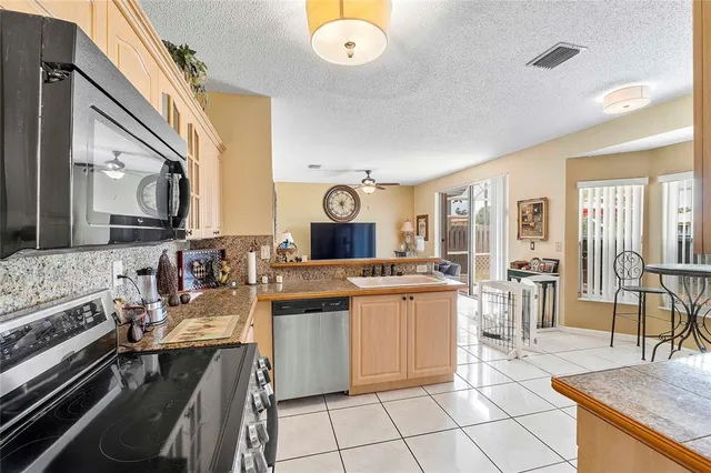 a large kitchen with stainless steel appliances granite countertop a stove and a sink