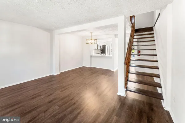 a view of a room with wooden floors and stairs