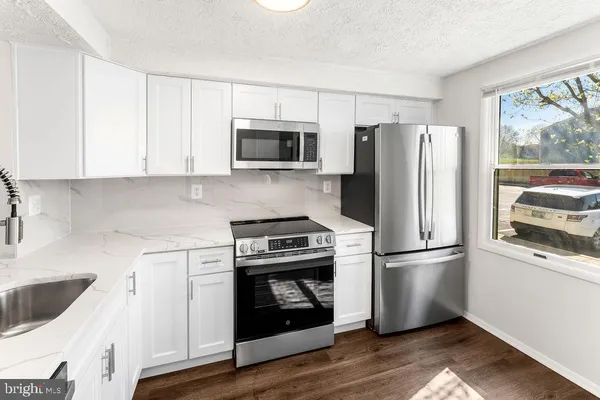 a kitchen with a refrigerator stove and microwave