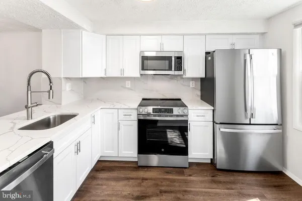 a kitchen with a refrigerator sink and cabinets