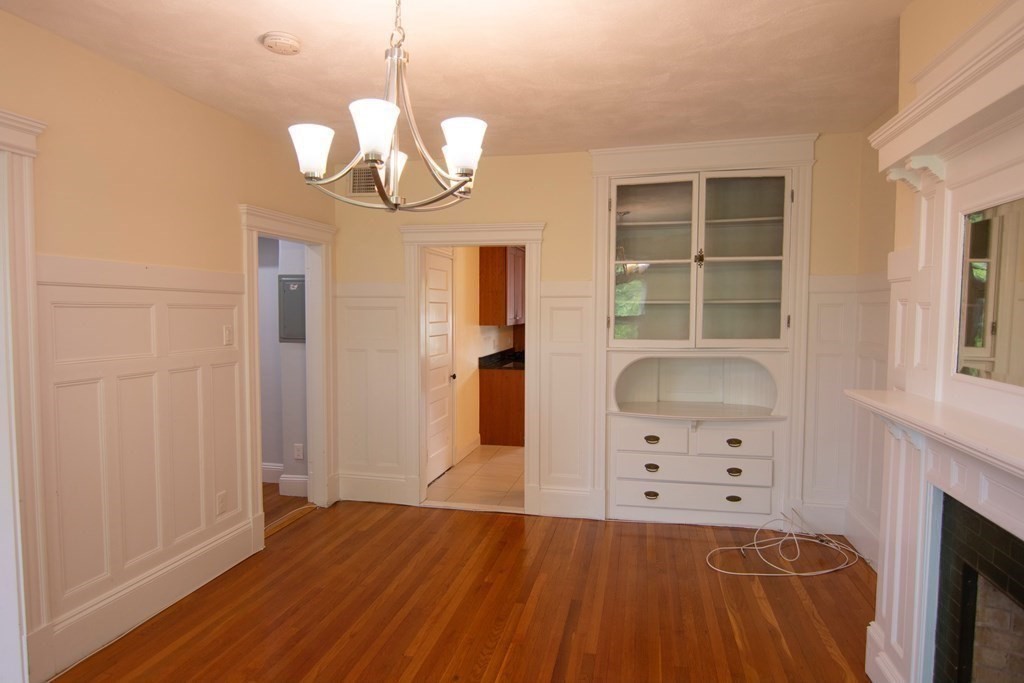 1897 Beacon Street, Unit 3 Brookline, MA 02445 - Photo 5 of 18 wooden floor in an empty room with a fireplace