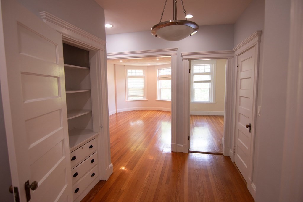 1897 Beacon Street, Unit 3 Brookline, MA 02445 - Photo 6 of 18 wooden floor in an empty room with a window