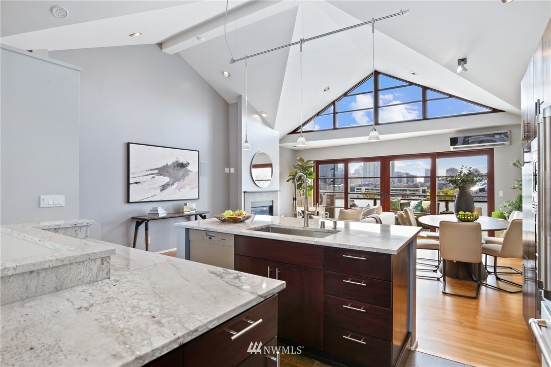 423 Ward Street Seattle, WA 98109 - Photo 12 of 39 a kitchen with a stove a sink dishwasher and a dining table with garden view