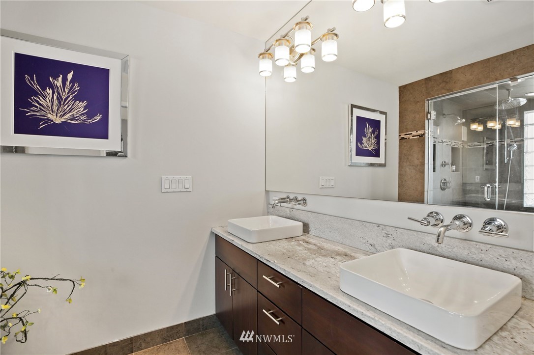 423 Ward Street Seattle, WA 98109 - Photo 24 of 39 a bathroom with a granite countertop sink a large mirror and a shower