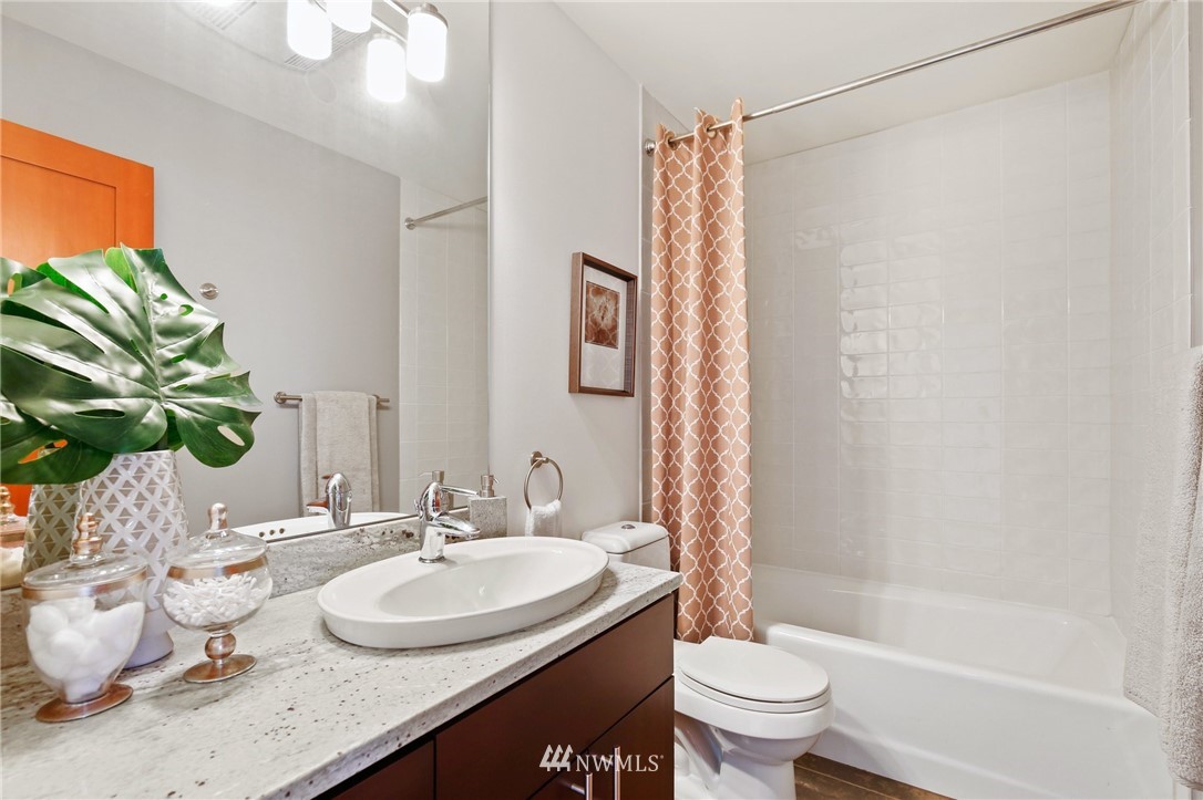 423 Ward Street Seattle, WA 98109 - Photo 29 of 39 a bathroom with a granite countertop sink a toilet and a bathtub