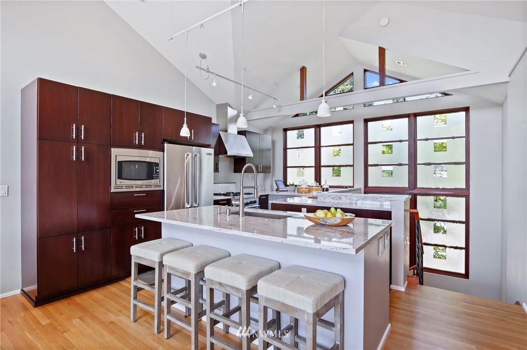 423 Ward Street Seattle, WA 98109 - Photo 9 of 39 a open kitchen with stainless steel appliances granite countertop a stove a refrigerator a oven a dining table and chairs with wooden floor