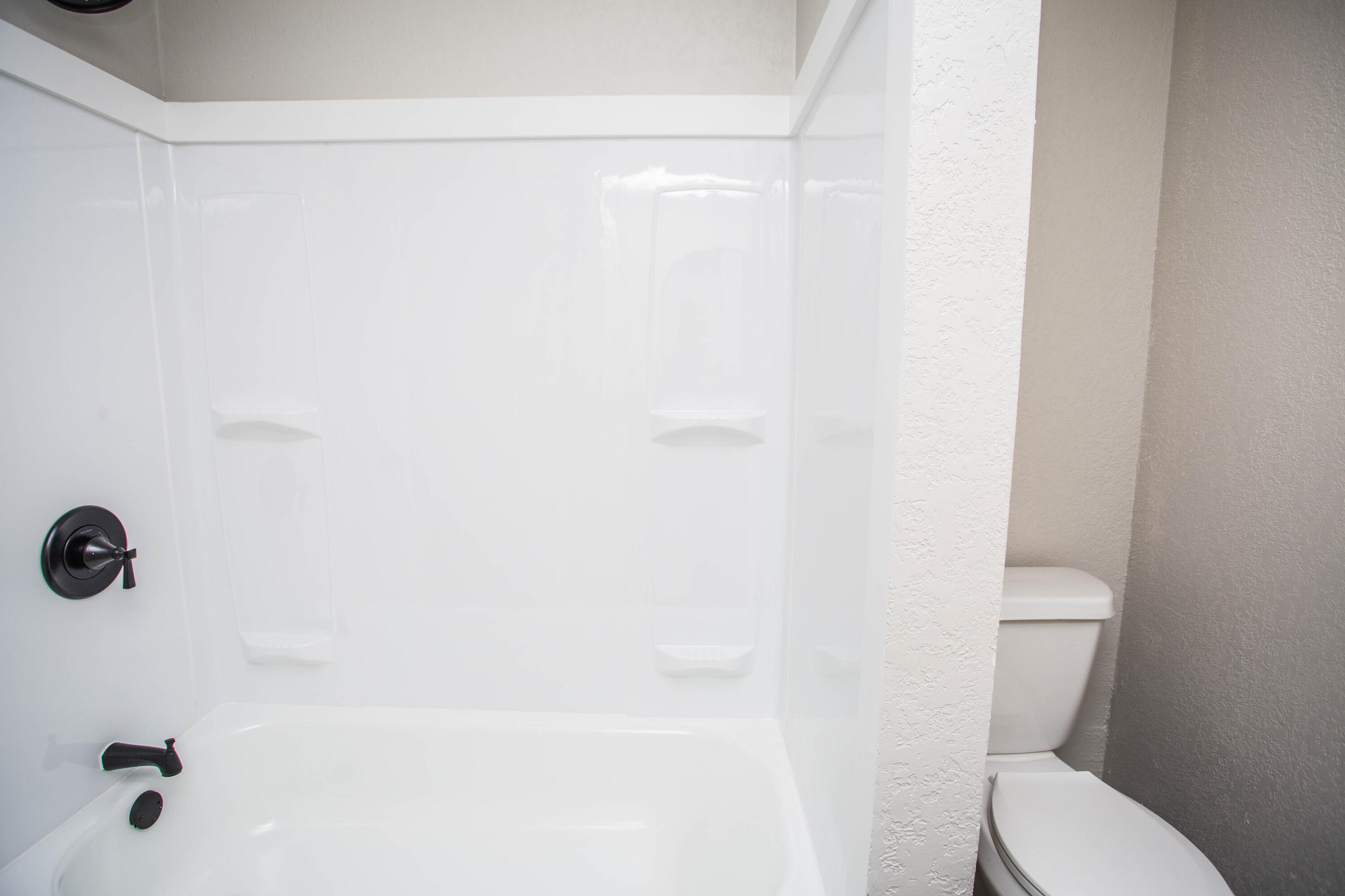 2725 63rd Street Lubbock, TX 79413 - Photo 15 of 41 a white toilet sitting next to a shower
